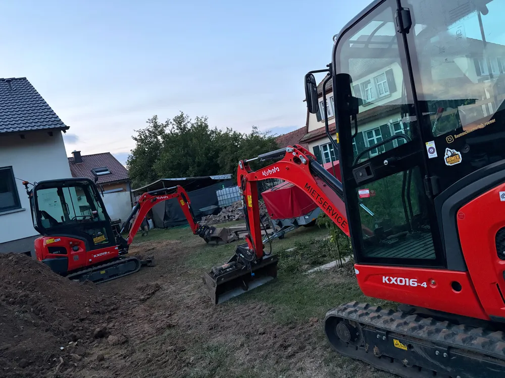 Zwei Kubota Minibagger bei Erdarbeiten neben einem Wohnhaus