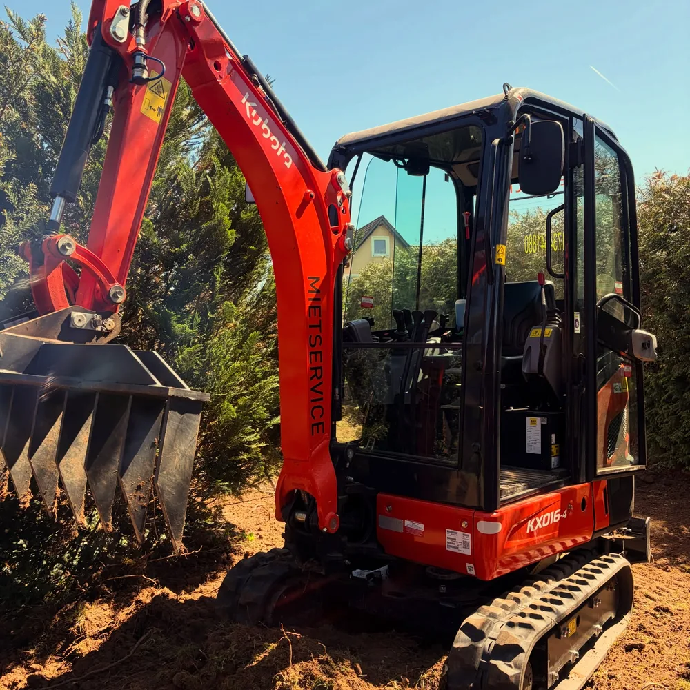 Kubota KX016-4 mit Roderechen am Ausleger bei Gartenarbeiten