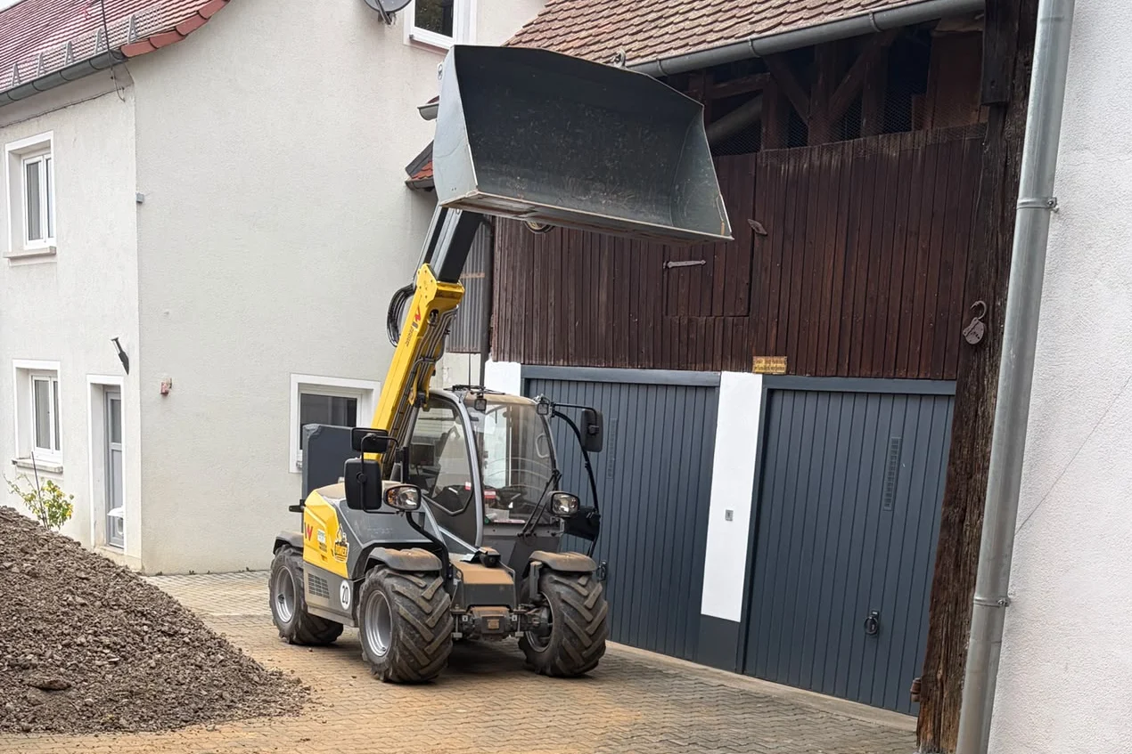Wacker Neuson Teleskoplader mit angehobener Schaufel im Hof in Hirschaid